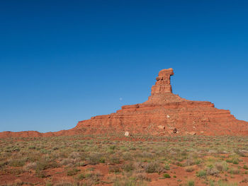 Low angle view of rock formations against clear blue sky