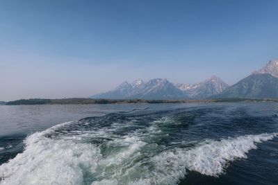 Landscape of boat wake on jackson lake and mountains in background at grand teton national park