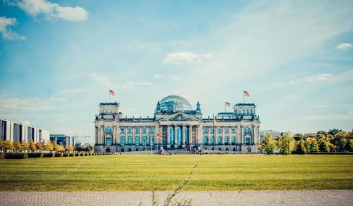 The reichstag building against cloudy sky