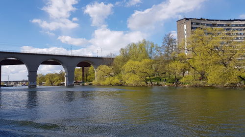 Arch bridge over river against sky