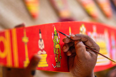 Close-up of hand holding red painting