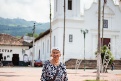 Senior adult woman at the central square in the city of guaduas. senior travel concept.