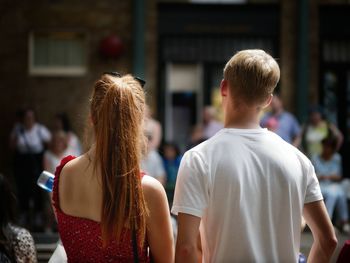 Rear view of people walking in town square