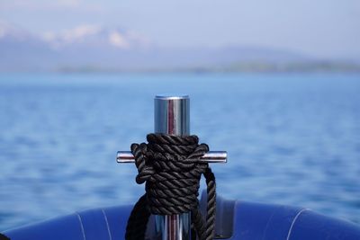 Close-up of black rope tied on boat in river