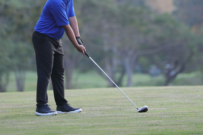 Low section of man playing golf