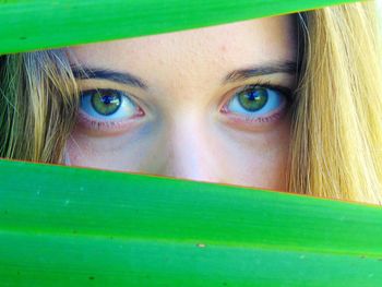 Close-up portrait of young woman seen through leaves