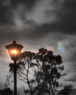 Low angle view of illuminated street light against sky