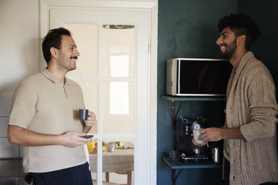 Gay couple drinking coffee at home