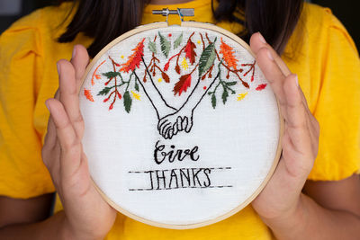 Midsection of woman holding paper with text