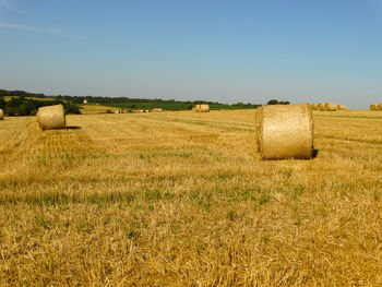 Hay bales on field against sky