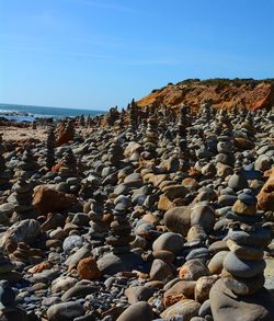 Rocks on beach against clear blue sky