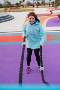 Portrait of smiling young woman standing in gym