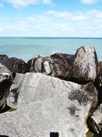 Scenic view of rocks on beach against sky