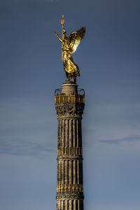 Sculpture on tower against sky