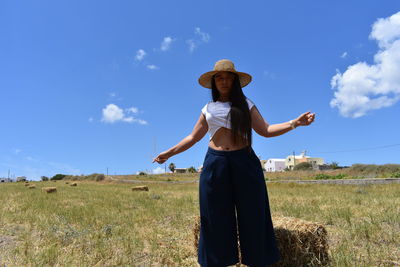 Full length of woman standing on field against sky