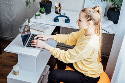 Sitting on gym ball at work. use exercise ball like chair at workplace. freelancer woman sitting on