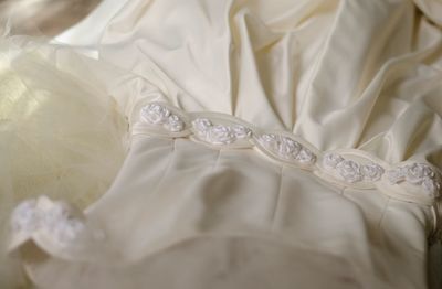 High angle view of wedding dress on bed