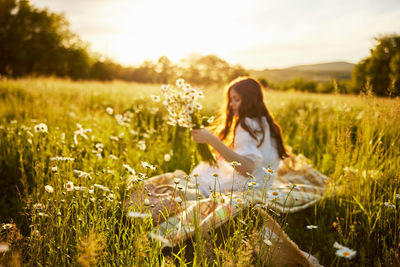Rear view of woman sitting on field