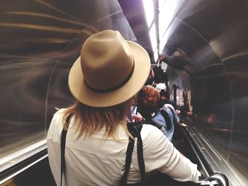 Rear view of man on escalator in subway