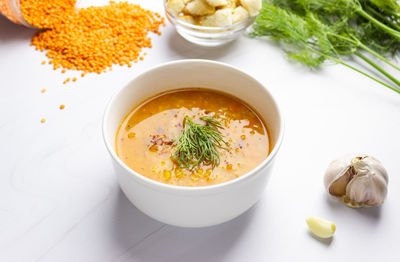 Red lentil soup with ingredients on a light background. traditional turkish or arabic spicy lentil