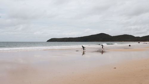 People on beach against sky