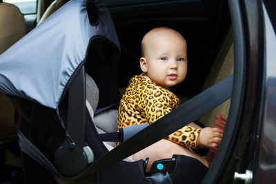 Portrait of smiling young woman sitting in car