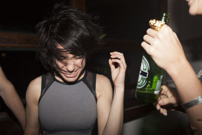 Young women enjoying a beer at a party