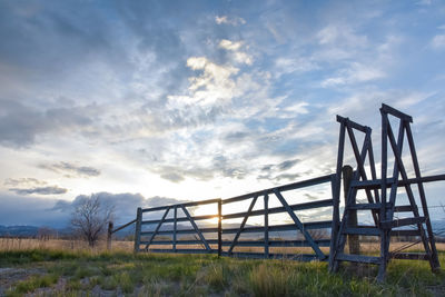 Low angle view of metallic structure on field against sky