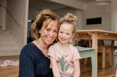 Portrait of mother and daughter with make up on their faces