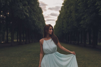 Young woman standing amidst trees