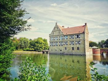 Building by lake against sky