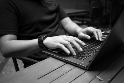 Midsection of man using laptop at desk