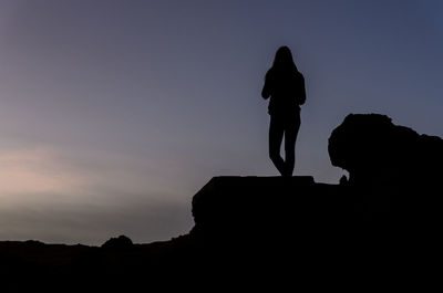 Silhouette of man standing on cliff
