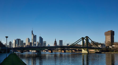 Bridge over river main with city buildings in background