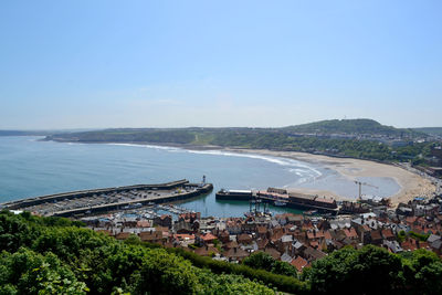 High angle view of town by sea against clear sky