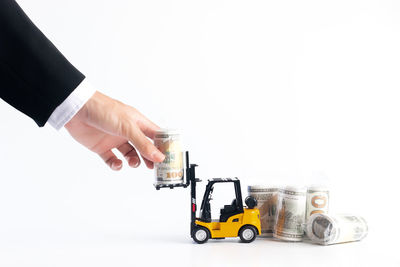 Hand holding toy car against white background