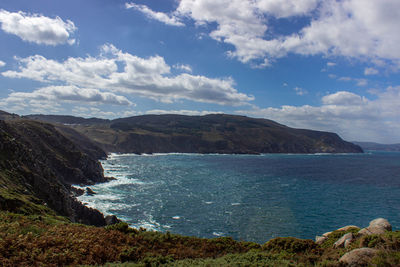 Scenic view of sea and mountains against sky