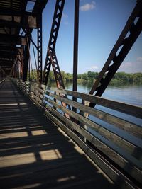 Footbridge over river against sky