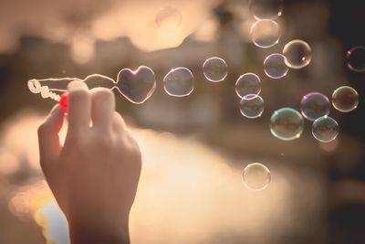 Close-up of woman holding bubbles