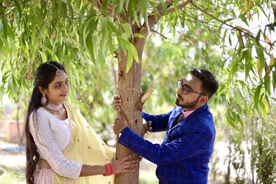 Side view of couple standing against plants