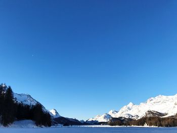 Scenic view of snow mountains against blue sky