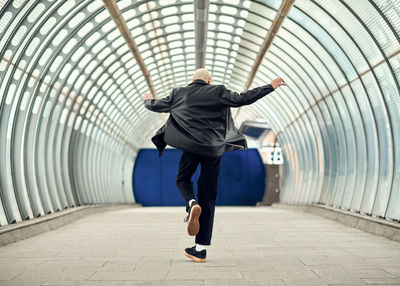 Rear view of man walking on footpath