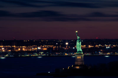 Statue of illuminated city at night