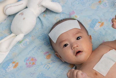 Portrait of cute baby lying on bed