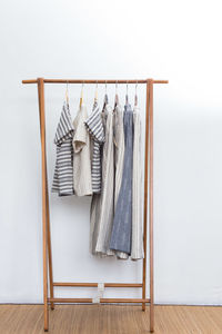 Clothes hanging on rack against white background