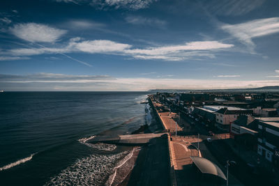 High angle view of buildings by sea against sky