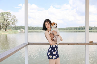 Portrait of young woman standing against sea