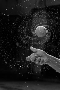 Cropped hand of boy spinning wet ball