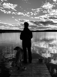 Rear view of man with dog standing in water