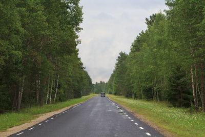 Road amidst trees against sky